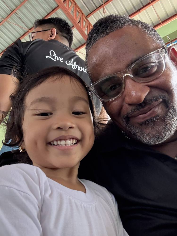 A smiling child with an MRD team member