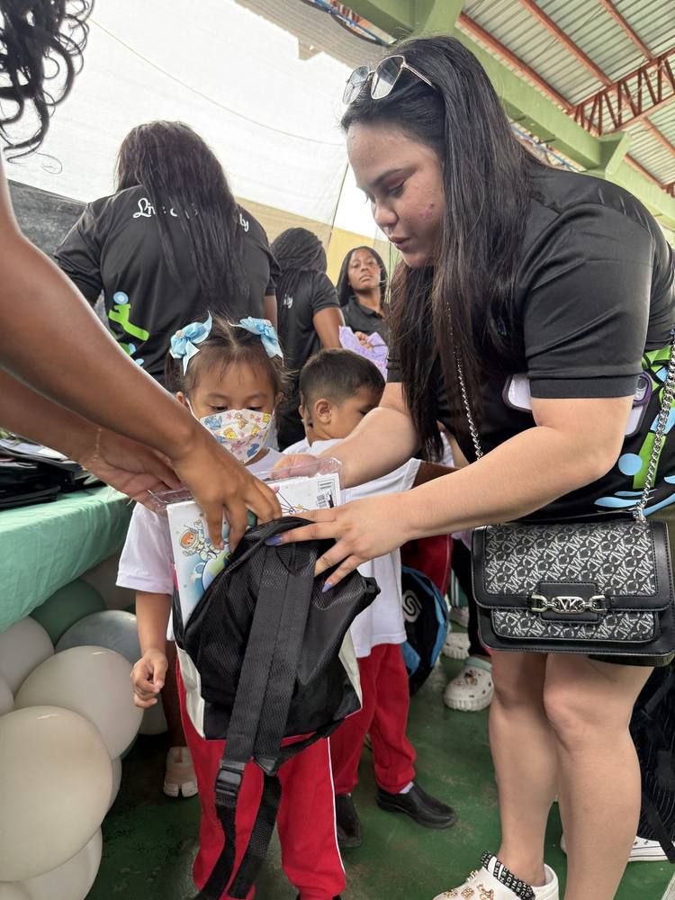 A child receiving a new backpack and school supplies