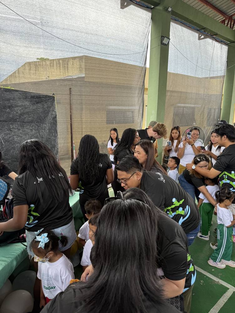 Team members side by side with the kids during the giveaway